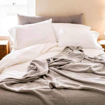 Bed with Organic Cotton Blanket with Herringbone Weave in Mountain Grey
