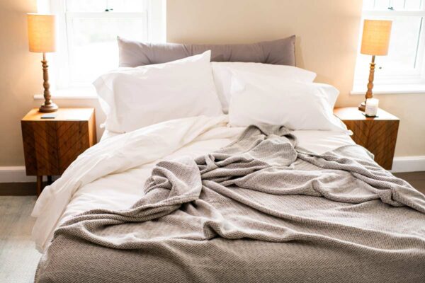 Bed with Organic Cotton Blanket with Herringbone Weave in Mountain Grey