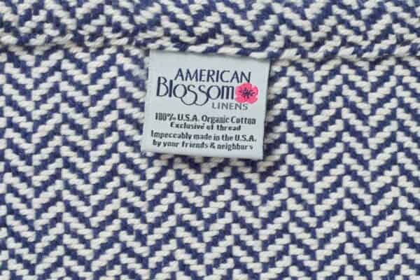 Close up of American Blossom herringbone twill weave organic cotton blanket in Patriot Blue.