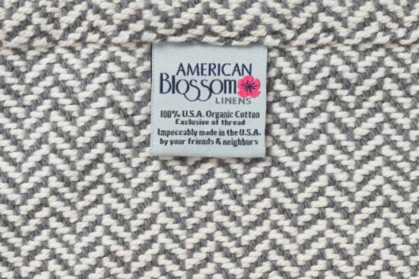 Close up of a herringbone twill weave for an organic cotton blanket in mountain grey.