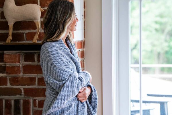 Woman holding an Organic cotton Blanket with Herringbone Weave in Patriot Blue