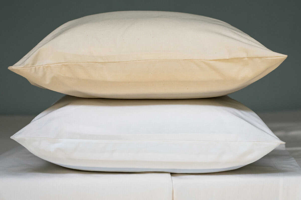 Two pillows stacked one in natural one in white